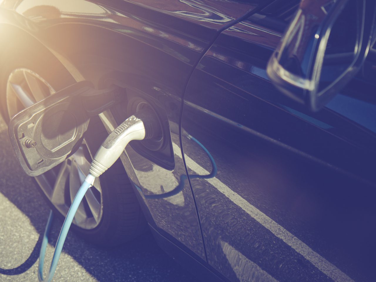 Recharging electric car by power cable. ...