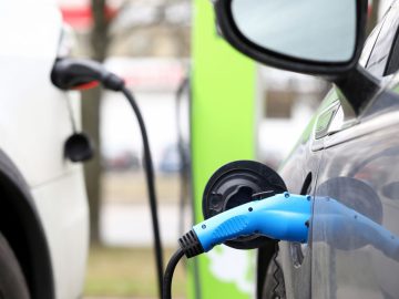 Close-up of electric car public charging station on city street. Power supply fo ...